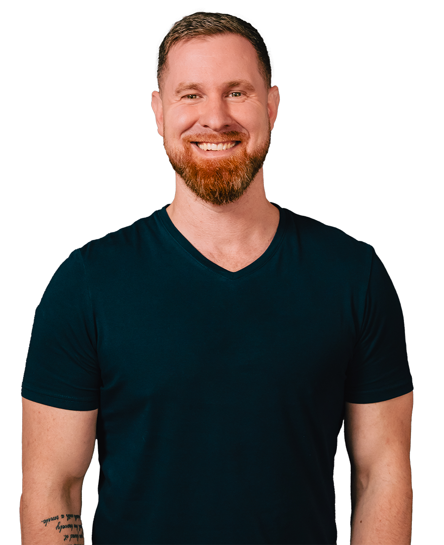 A man with a beard is wearing a blue shirt and smiling.