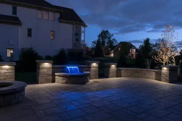 Stone Patio with a fountain.  Pathway lighting is warm, and fountain light is blue.  All automated for mood.