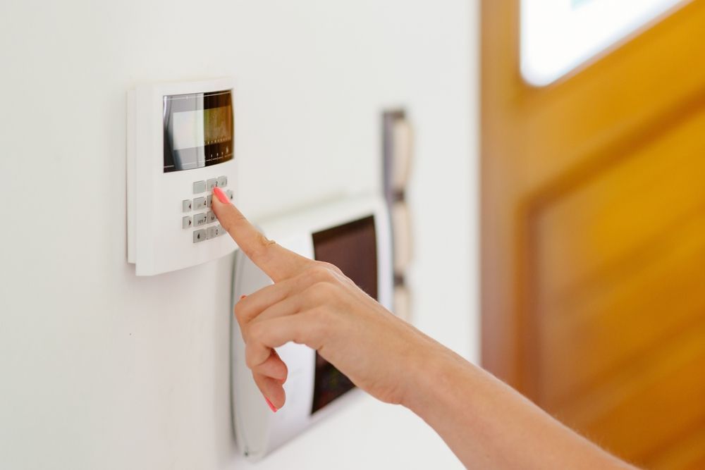 A person is pressing a button on a security system.