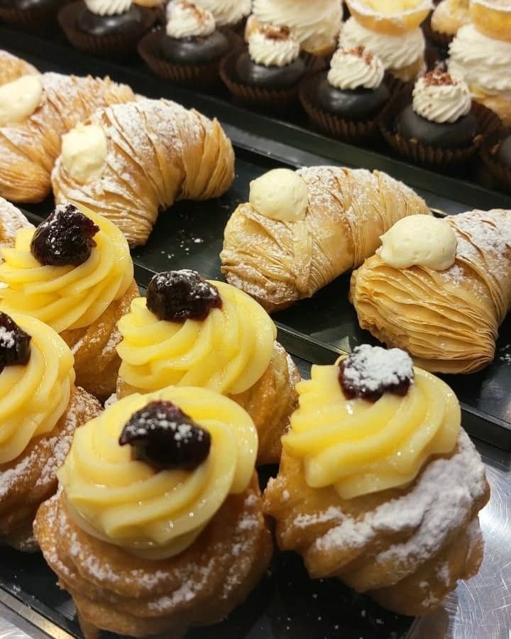 Pasticcini esposti: sfogliatella, bignè e cupcakes al cioccolato con panna montata.