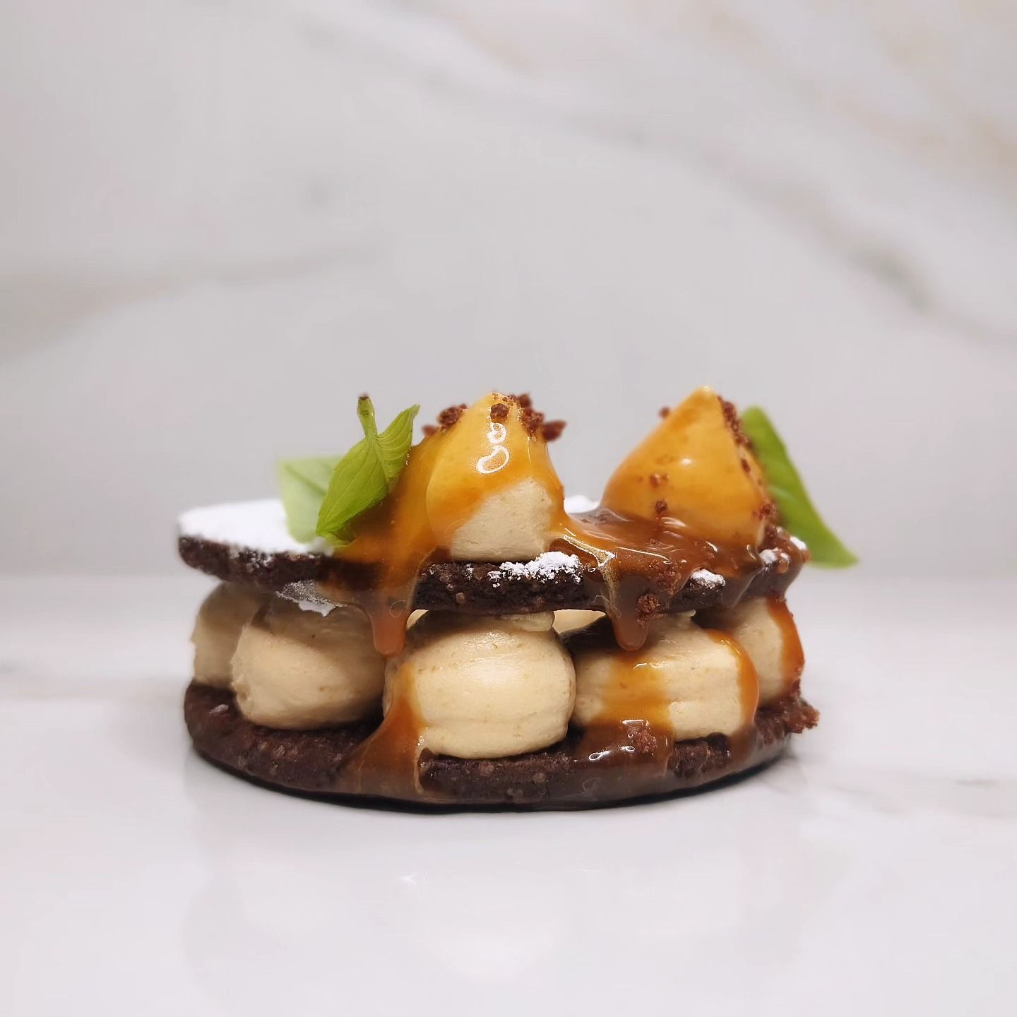 Dessert al cioccolato con strati di panna, caramello e frutta.