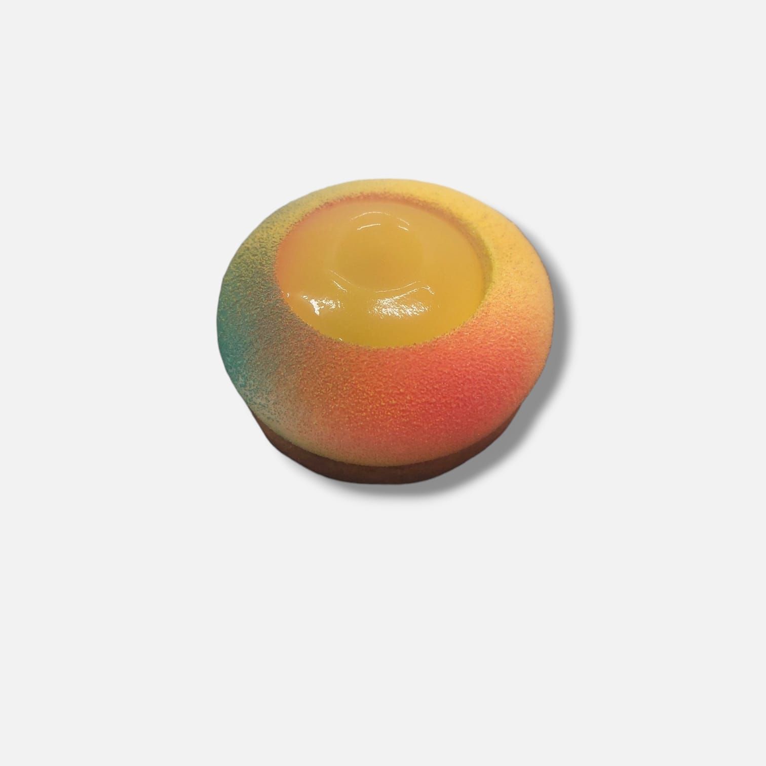 Pasta sferica colorata con ripieno giallo. Esterno sfumato di arancione, giallo e verde acqua.