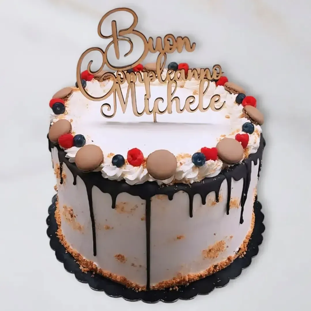 Torta decorata con frutti di bosco, macarons e gocce di cioccolato, con la scritta