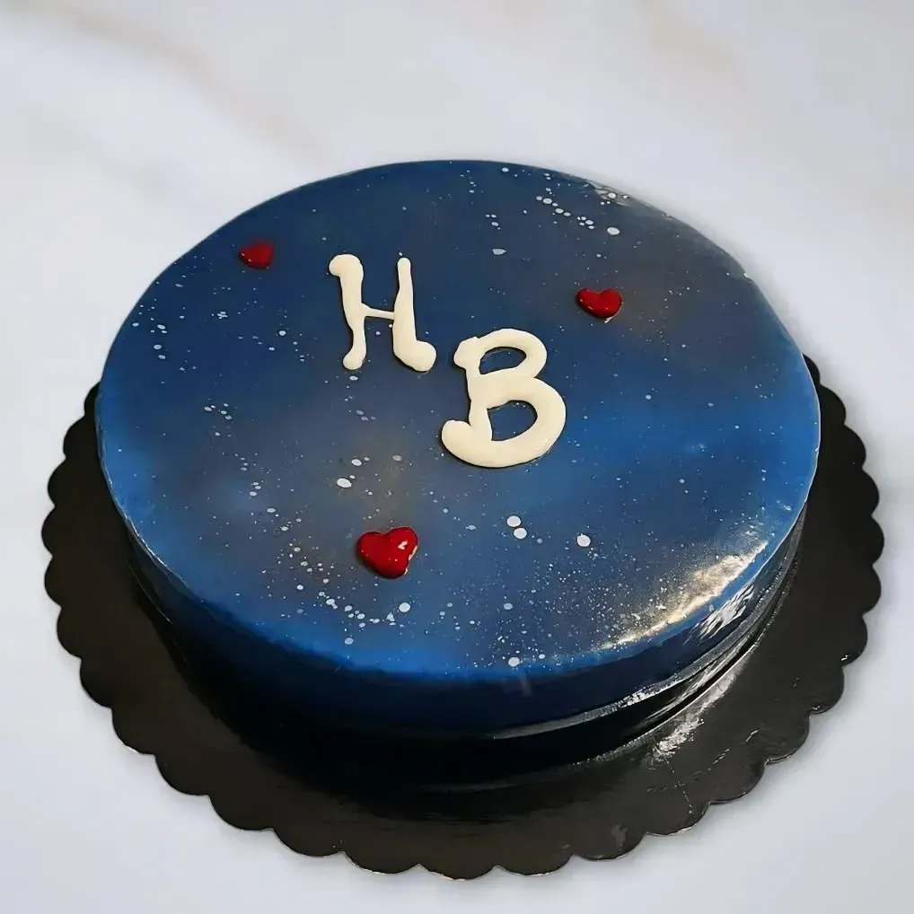 Torta rotonda blu con iniziali bianche