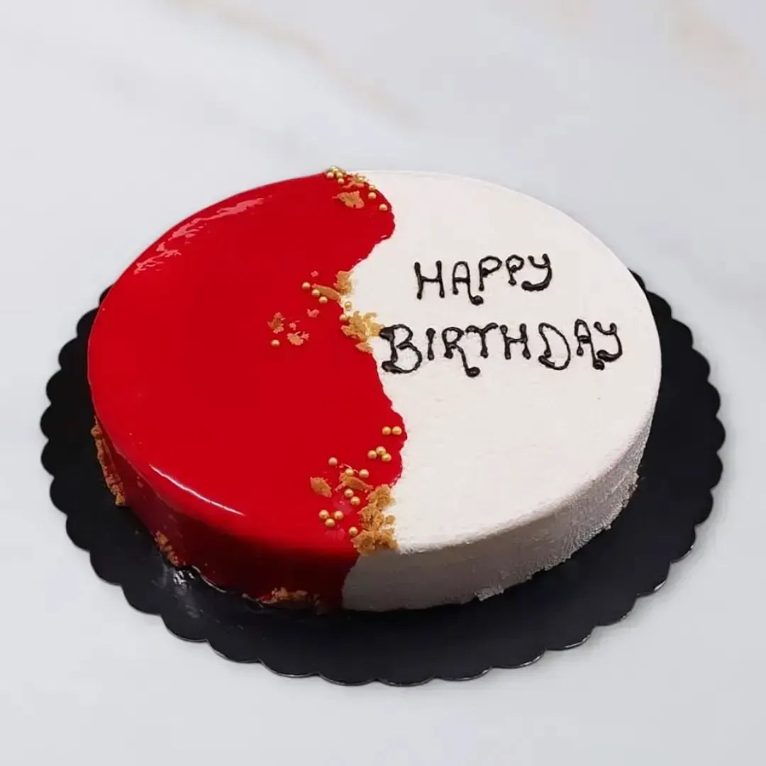 Torta di compleanno rossa e bianca su un piatto nero con la scritta