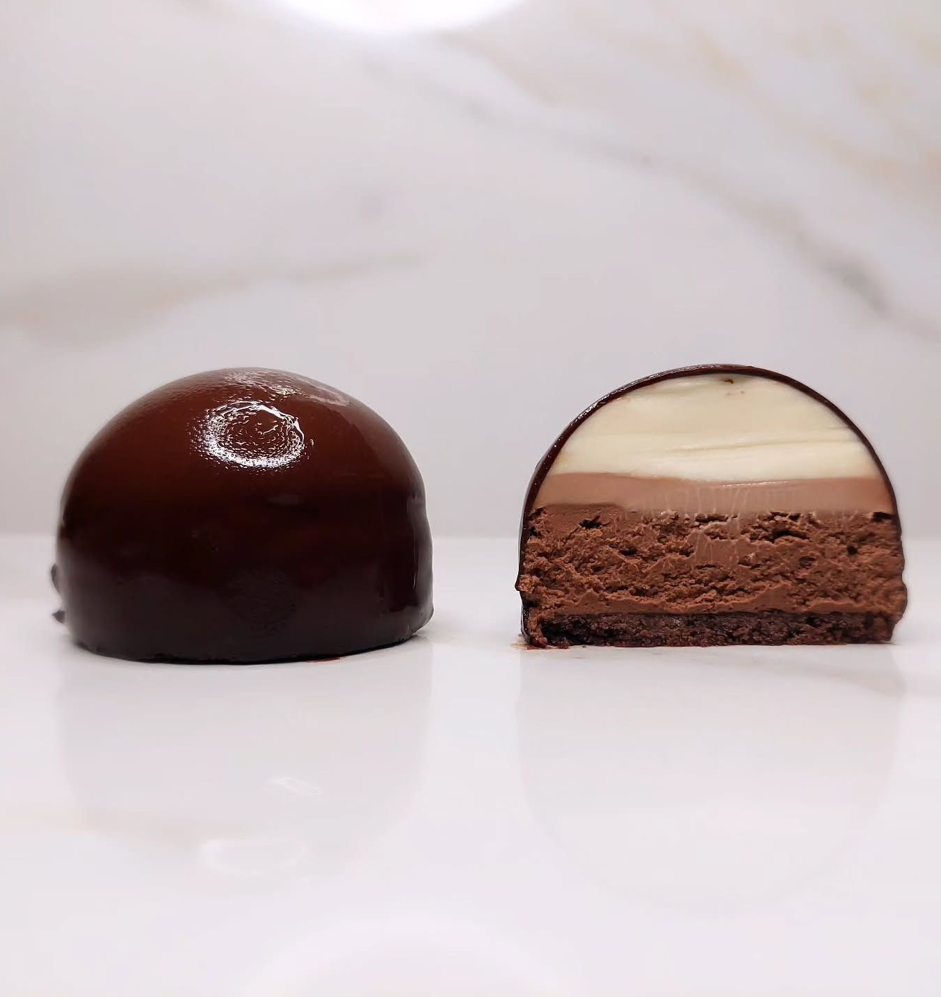 Torta di pasta sfoglia al cioccolato, tagliata, che rivela strati di cioccolato fondente, al latte e bianco