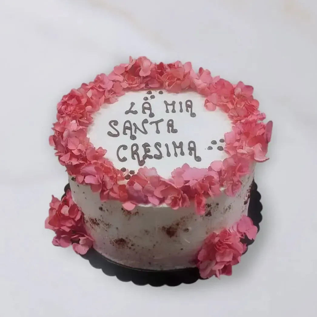 Torta decorata con fiori rosa, con la scritta