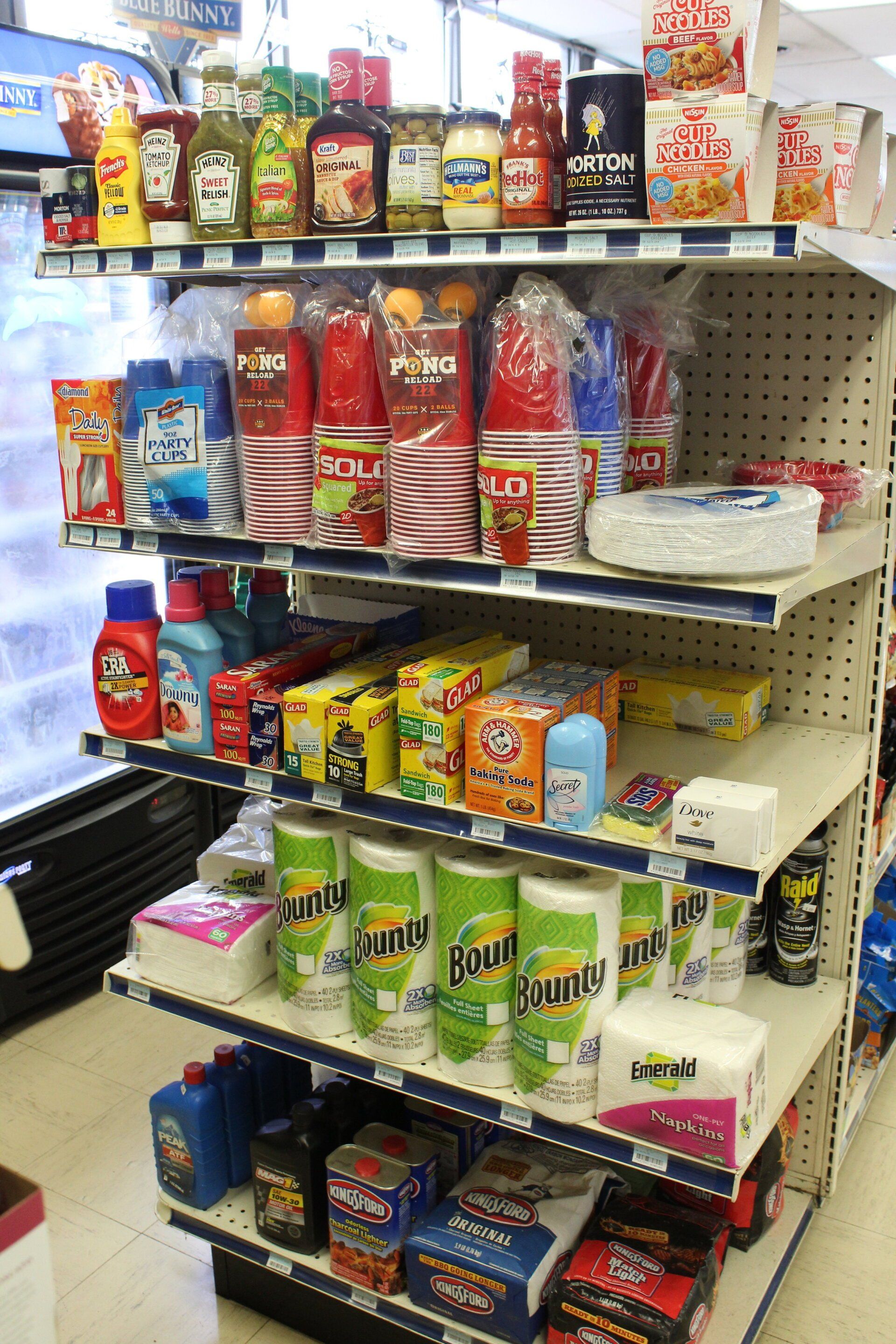 A store shelf filled with lots of items including paper towels