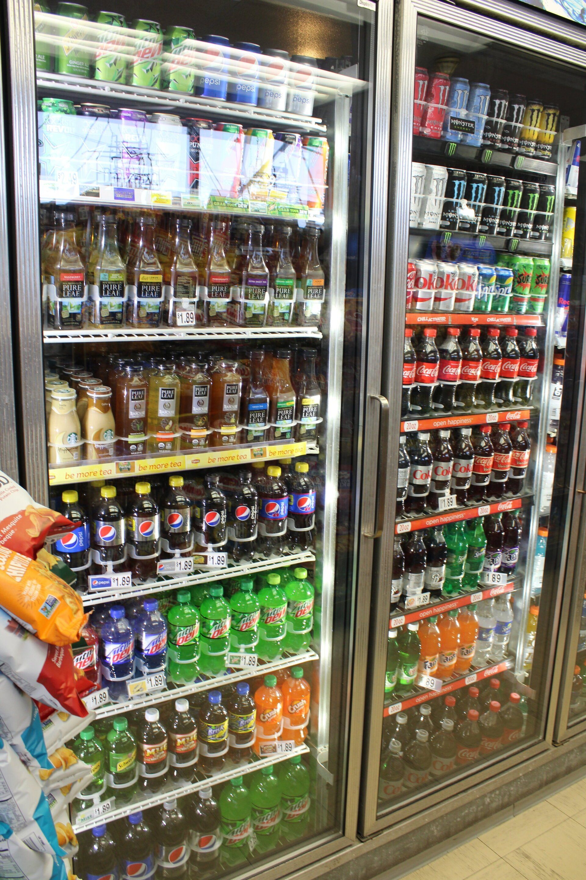 A refrigerator filled with lots of sodas including pepsi and fanta