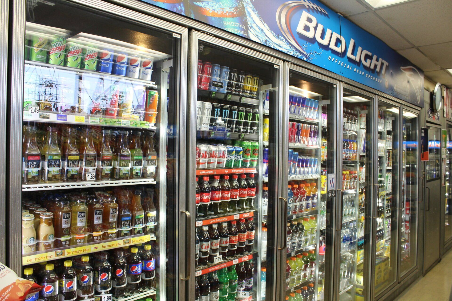 A grocery store with a bud light sign on the wall