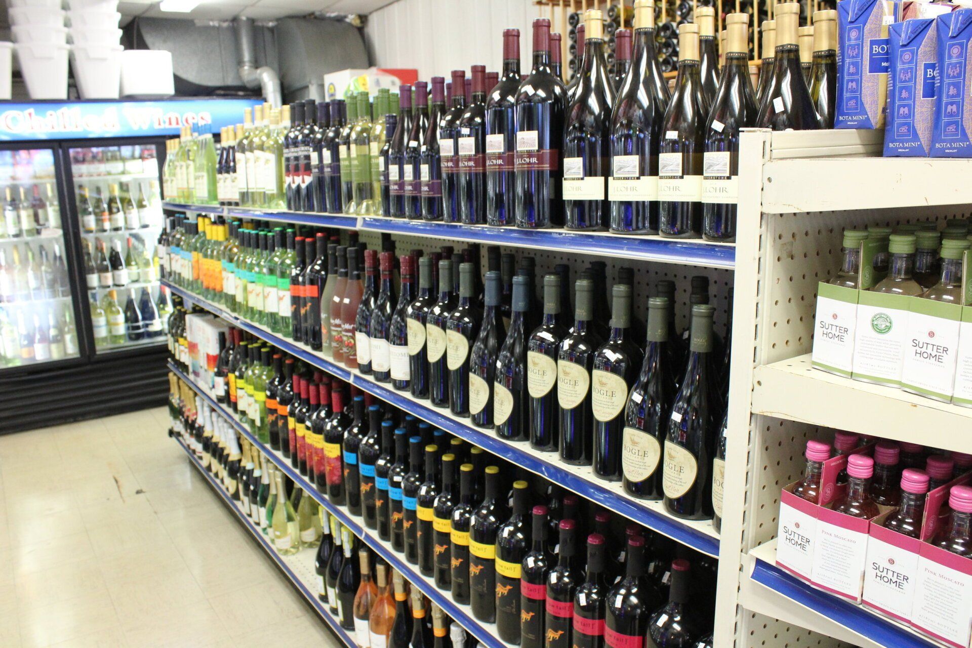 A grocery store aisle filled with lots of wine bottles.