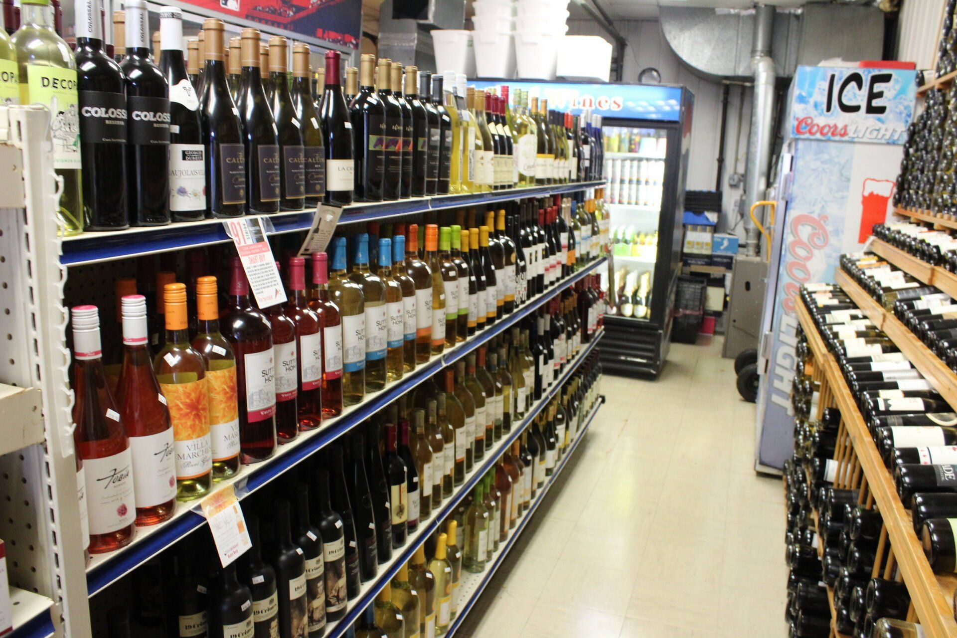 Bottles of wine are lined up on shelves in a liquor store