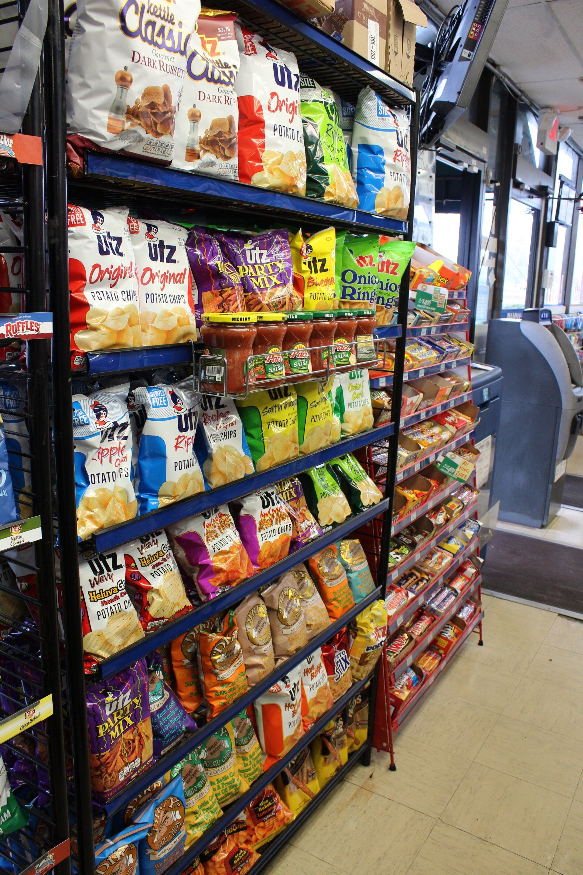 There are many bags of chips on the shelves in this store.