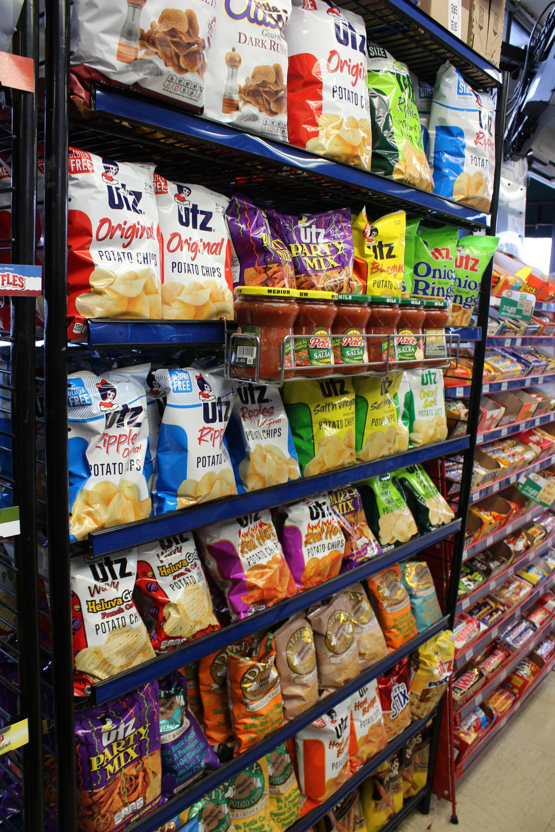 A shelf filled with bags of chips in a store.