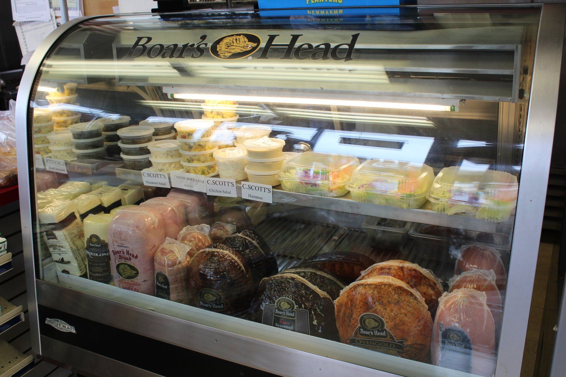 A display case filled with a variety of Boar's Head meats and cheeses.