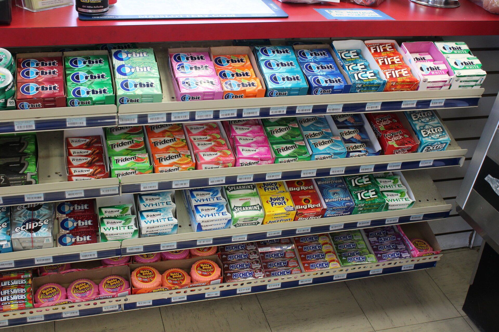A store shelf filled with a variety of chewing gum