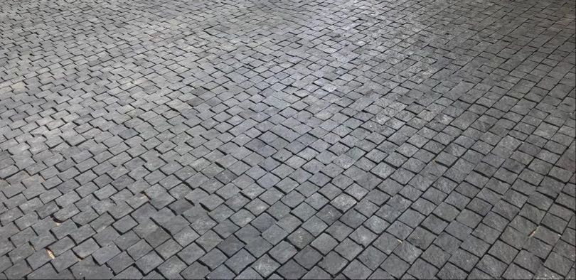 Anello in oro con perla scura, accanto a uno schizzo su una superficie di legno.