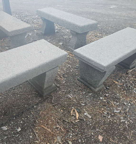 Anello d'oro a forma di e commerciale in una scatola bianca con un logo, accanto al quale è appoggiato un filo d'oro.