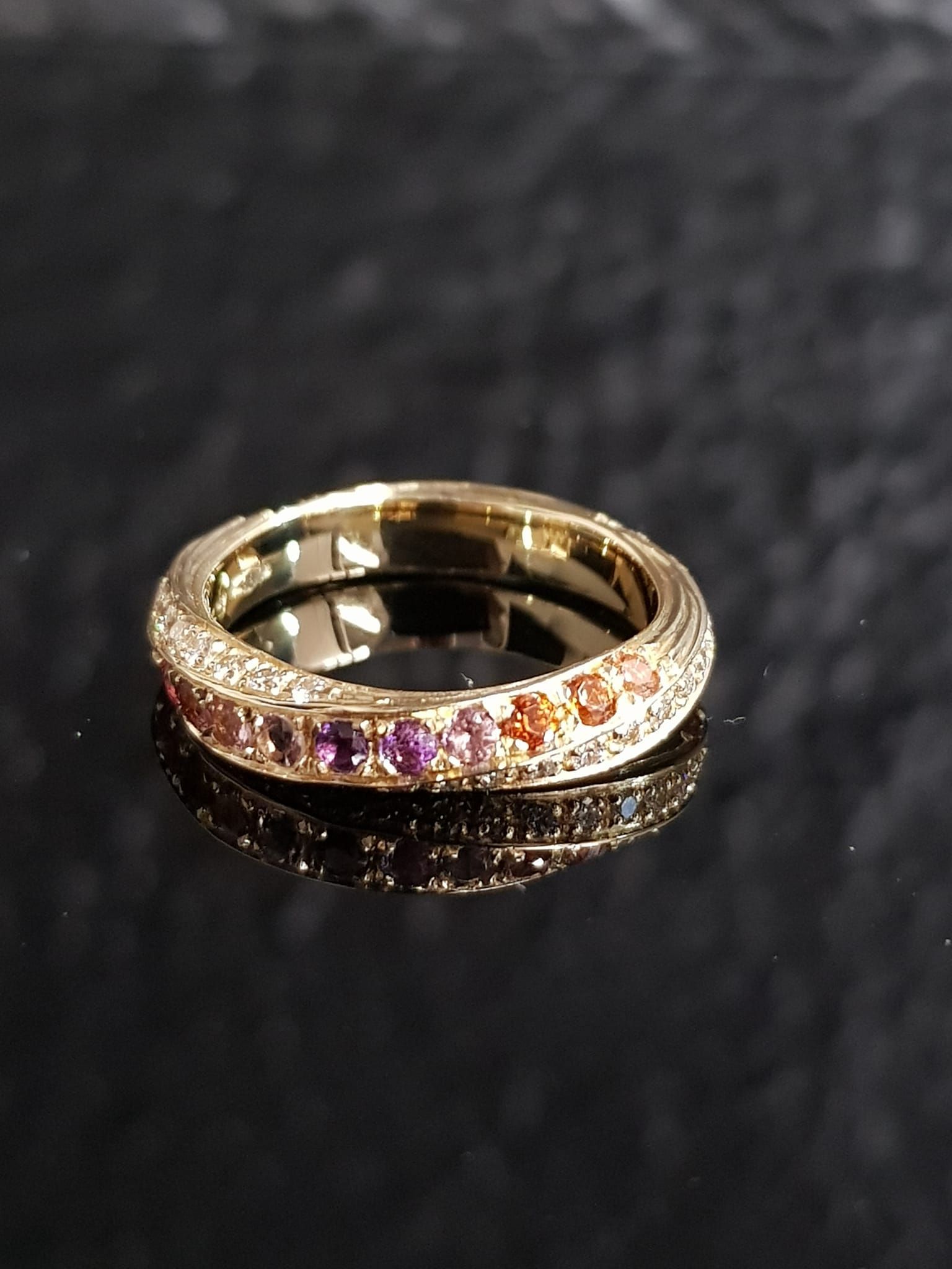 Anello in oro con pietre preziose incastonate in vari colori.