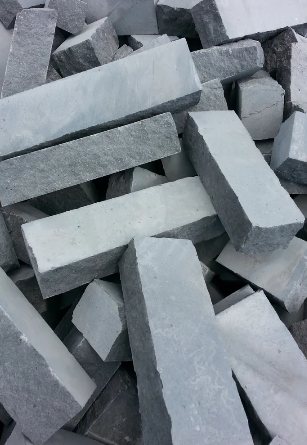 Due fedi nuziali d'oro intrecciate, con un lungo oggetto d'oro ricurvo e particelle marroni sparse.