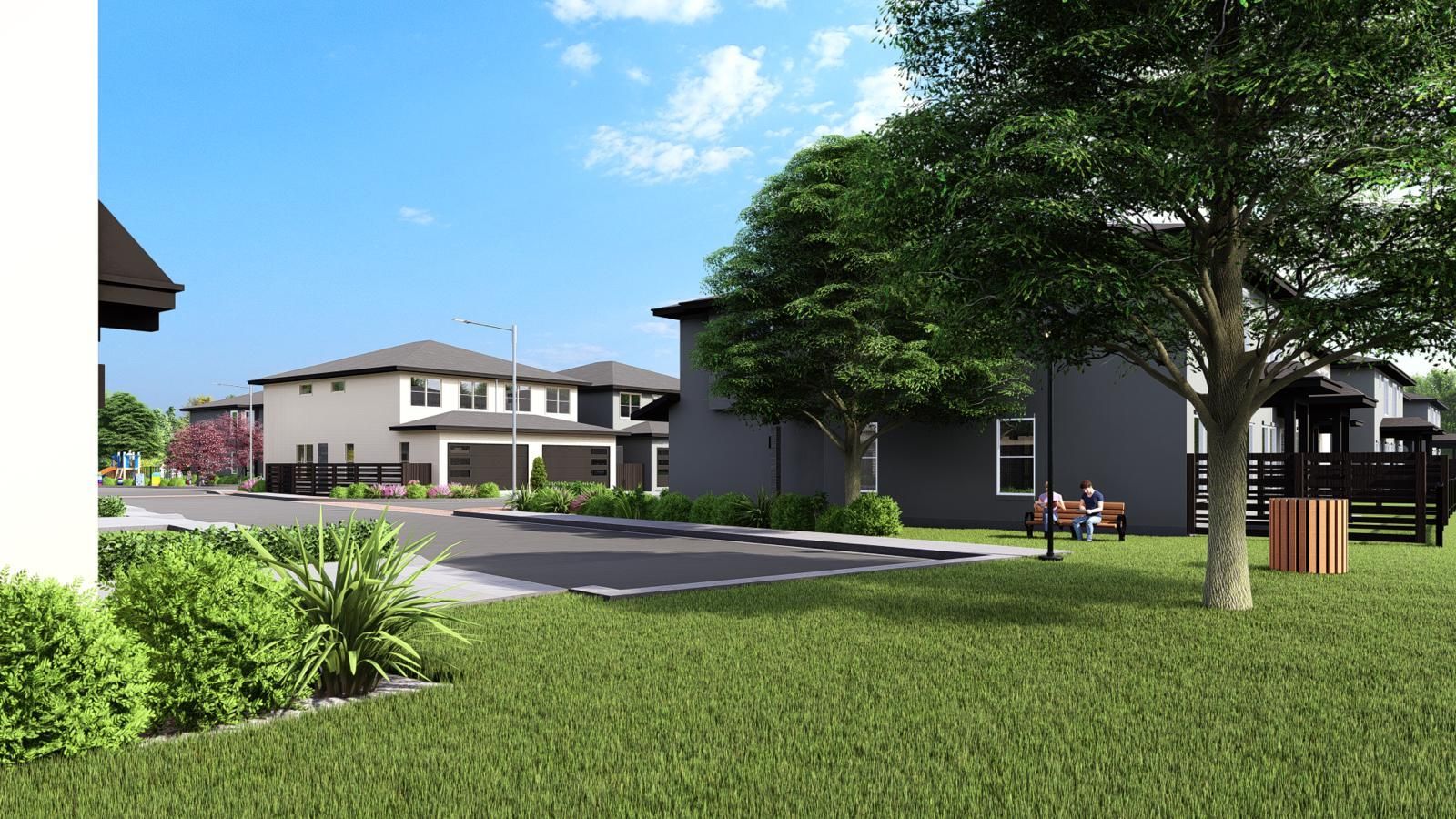 Residential buildings with a park area, green grass, and trees under a blue sky with some people sitting on a bench.