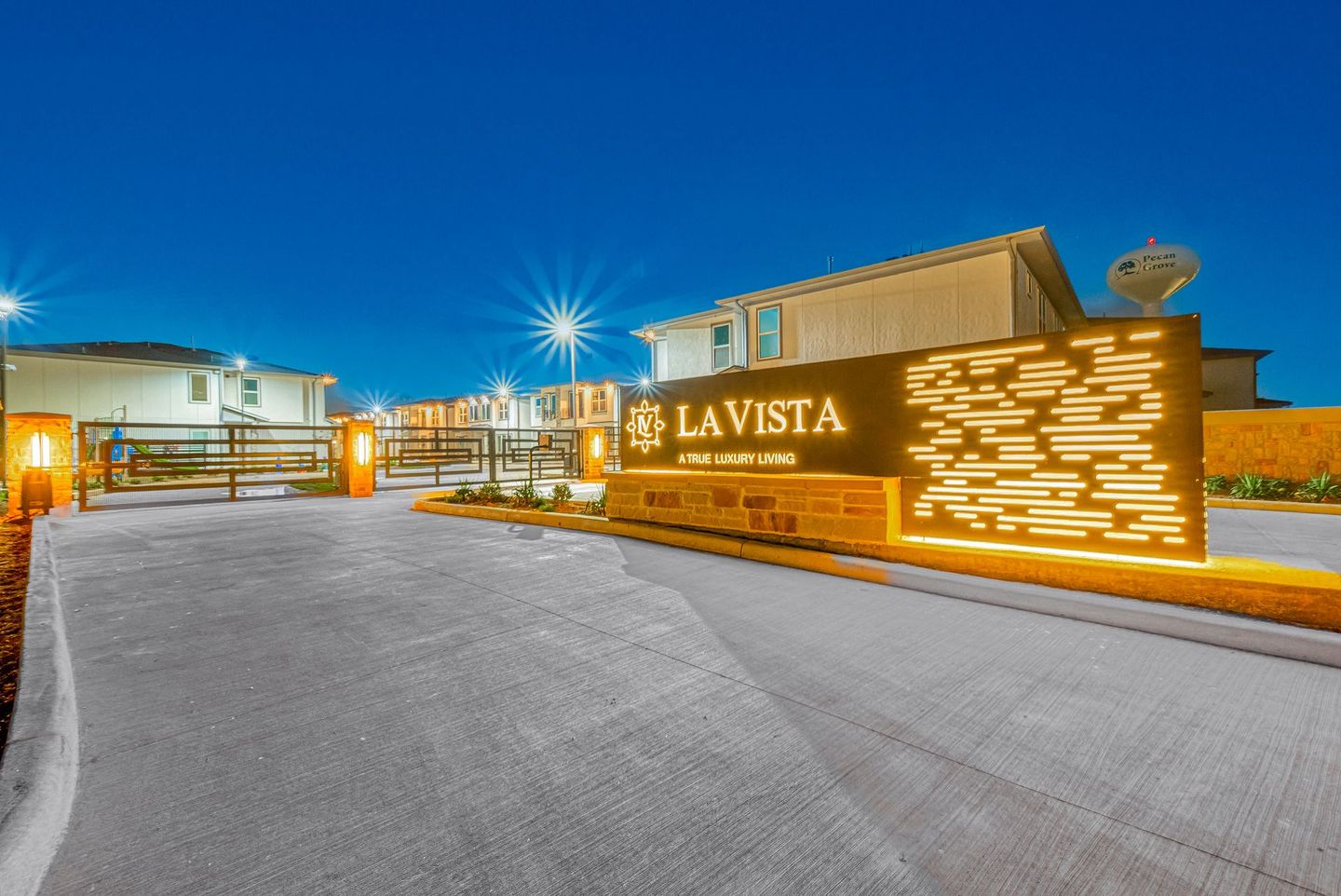 Lit-up La Vista building entrance at dusk with a wide paved driveway and starry lights