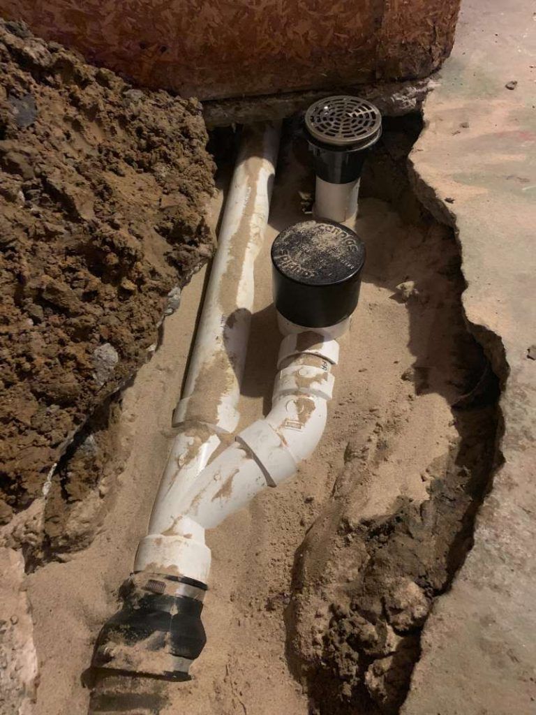 A white pipe is laying in the dirt next to a hole in the ground. Northglenn, Colorado accountable home services