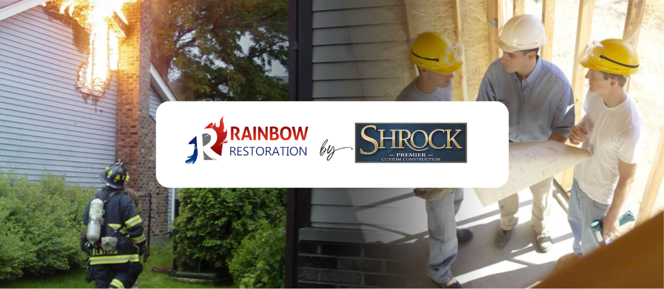 A fireman is walking in front of a house with a fire in the background and two men with hard hats conversing.