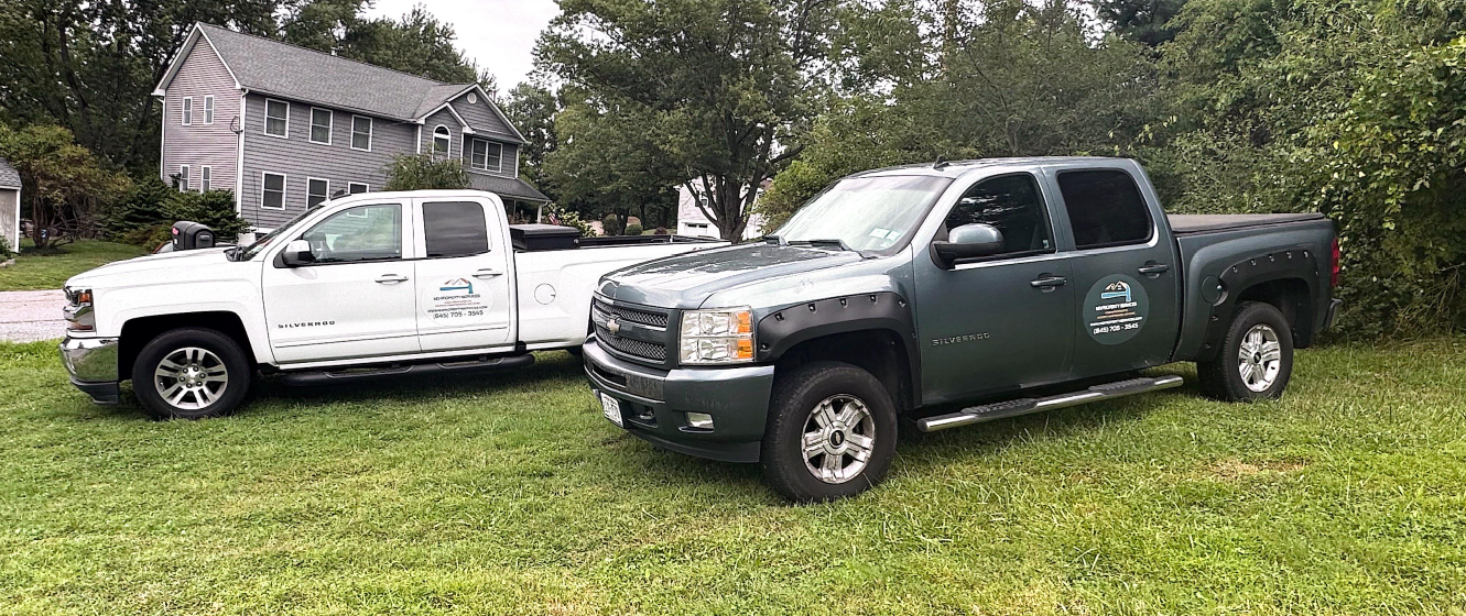 Man in red pants paints white step outdoors.
