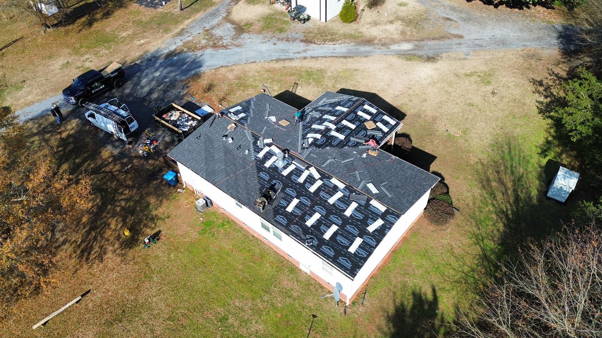 An aerial view of a house with a roof that is being repaired.