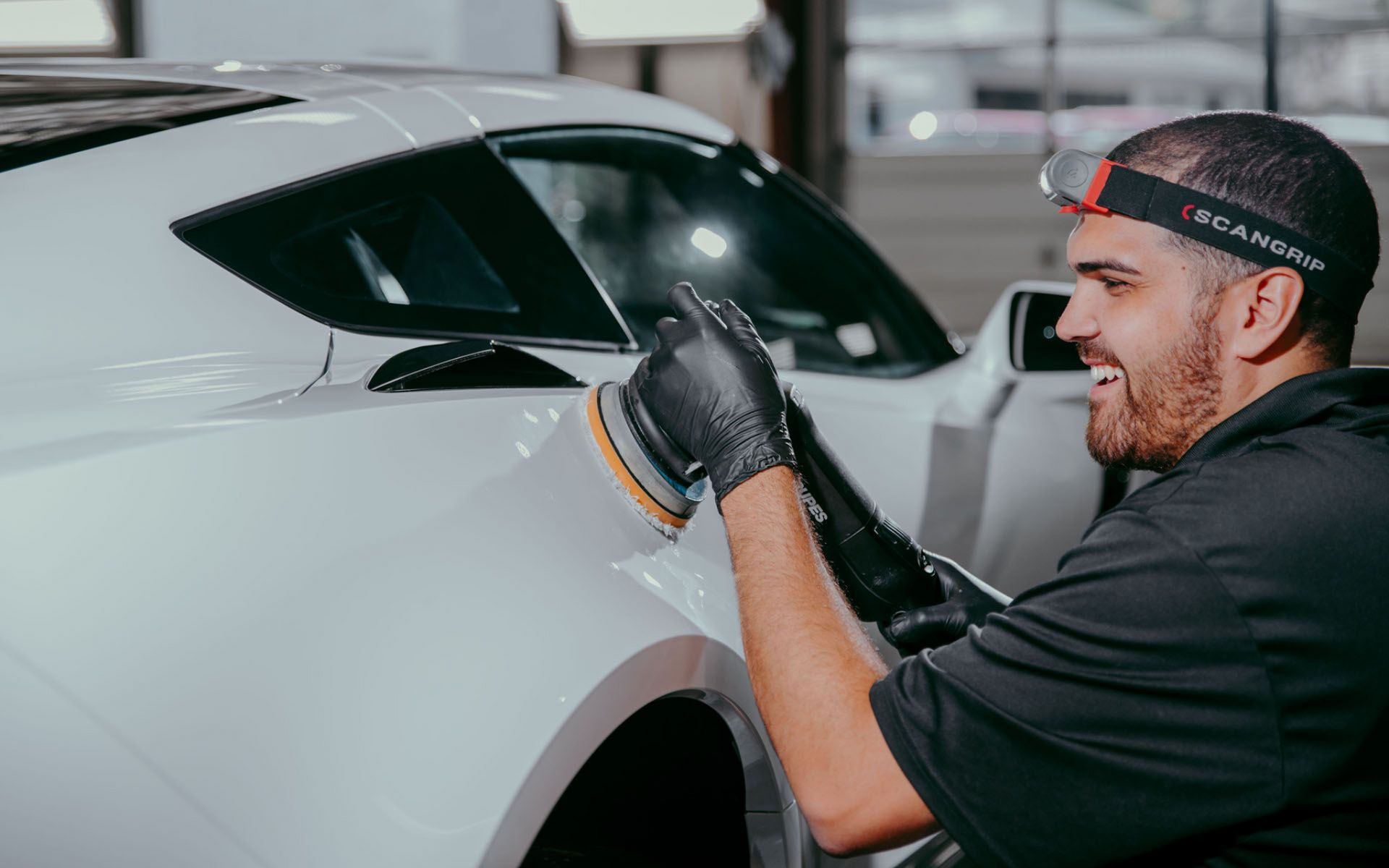 A blue car with flames painted on the hood is parked on the side of the road.