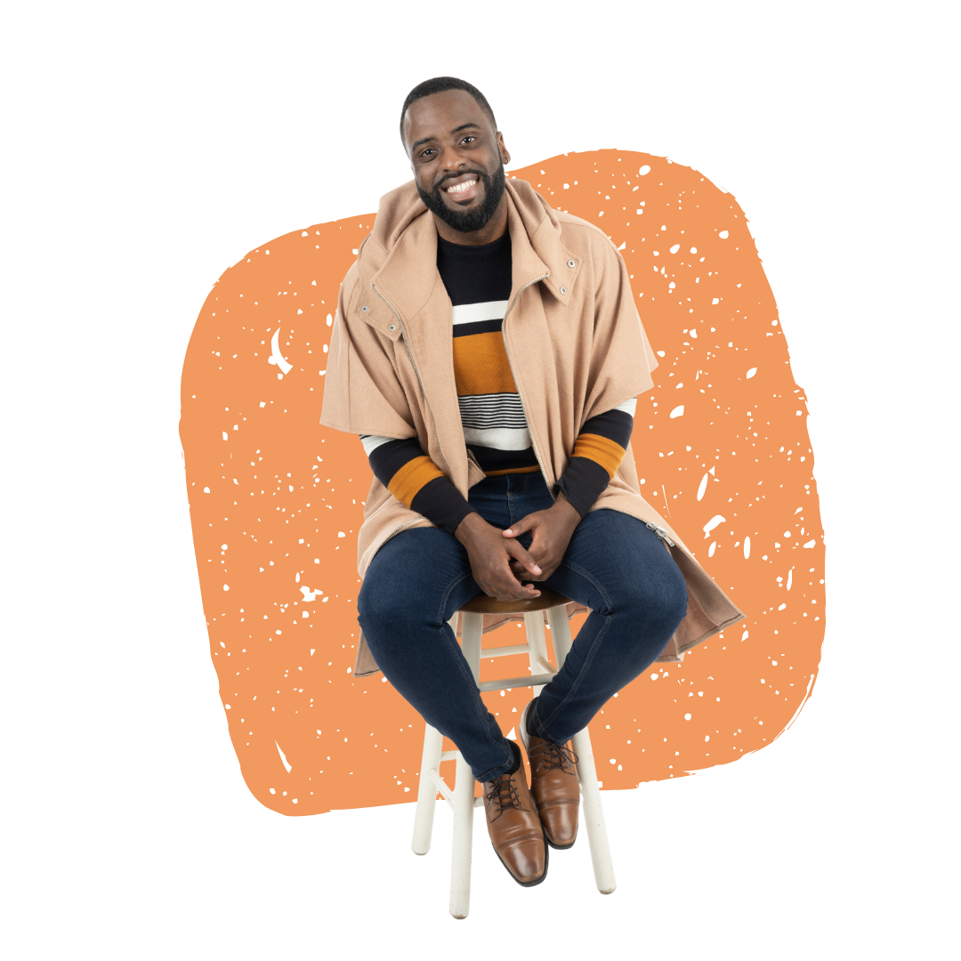 Tony Shavers III smiling, sitting on a stool, wearing a sweater and tan coat, against an orange shape.