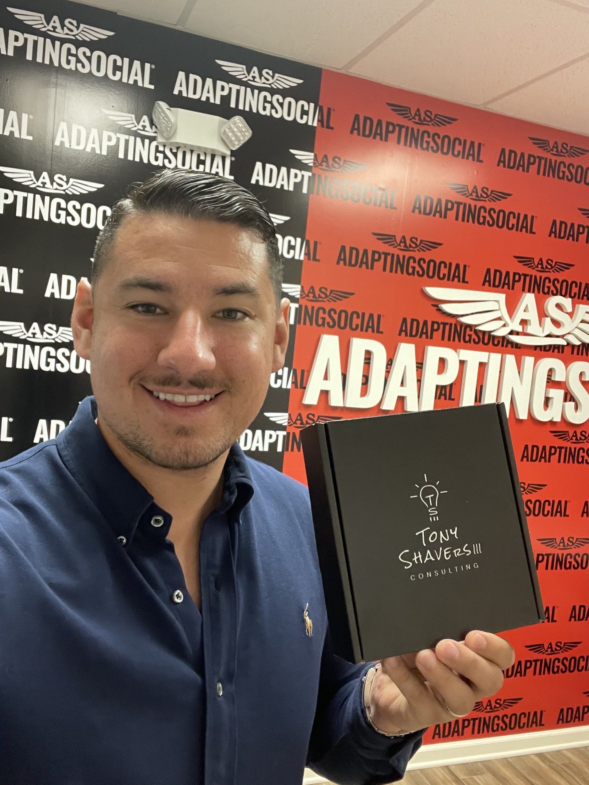 A triumphant Latino social marketer smiles while holding his new Press Reset affirmation card deck.