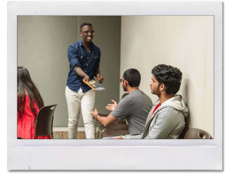 Personal development coach Tony Shavers III giving his book to a workshop attendee