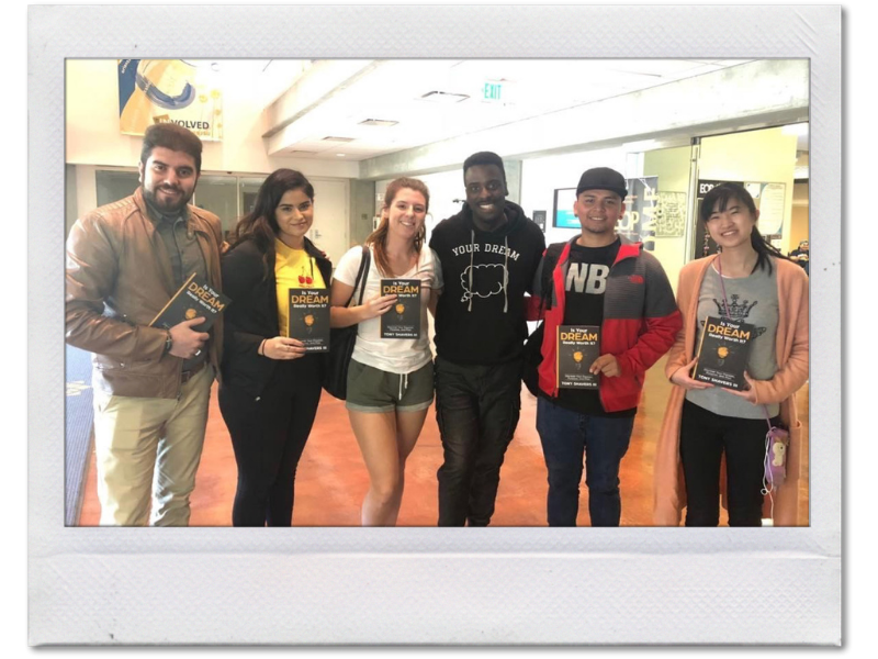 A row of smiling college students holding the self discovery book