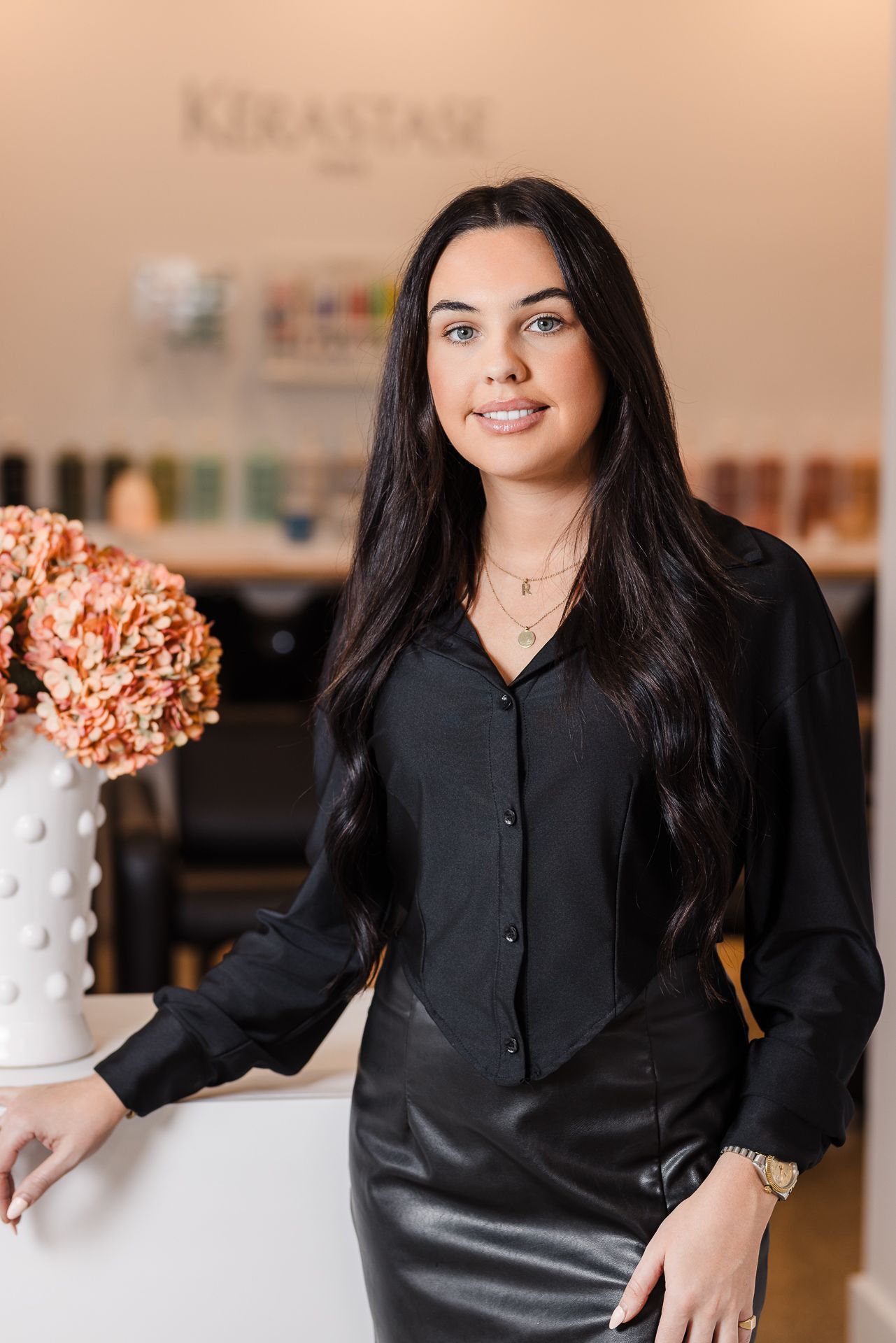 A woman is standing in front of a counter in a hair salon.