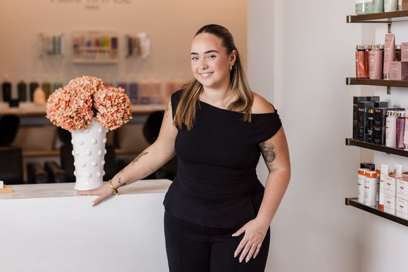 A woman is standing in front of a counter in a salon.