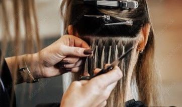 A woman is getting her hair done by a hairdresser.