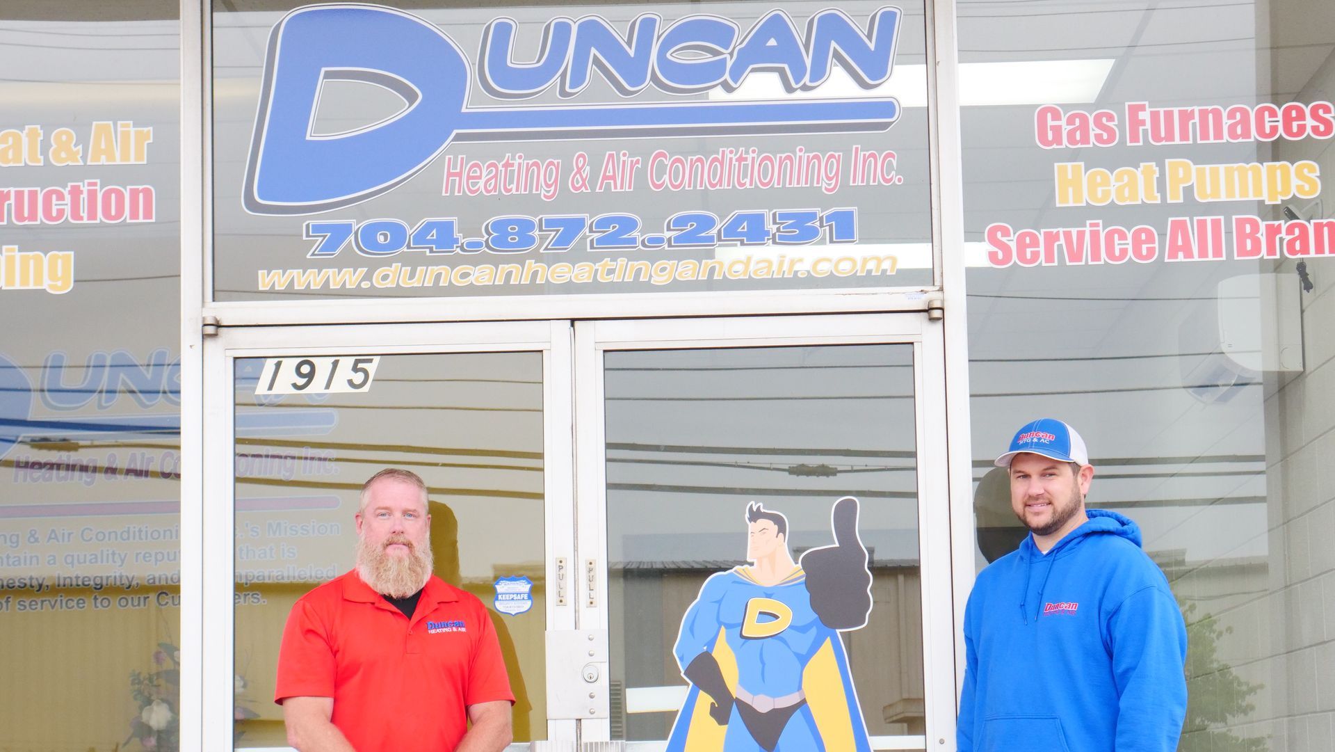 Two men are standing in front of a building that says duncan