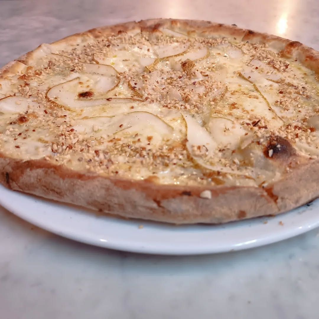 Pizza con mozzarella, pera, gorgonzola e granella di nocciole