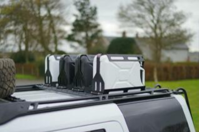 Picture of empty jerry cans strapped to the top of a vehicle.