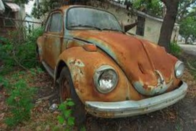 Picture of a scrap vehicle beetle vehicle that is rusted and broken down.