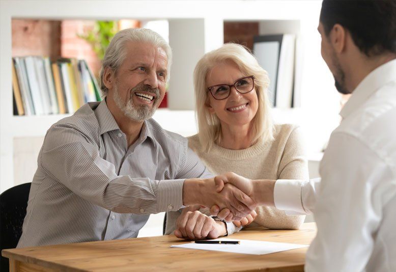 Happy Old Couple Clients Make Financial Deal Handshake — Saint James, MN — Laurels Agency Inc