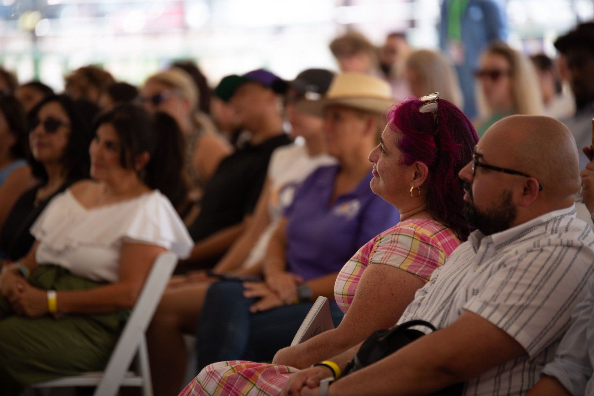 A group of people are sitting in chairs watching a presentation.