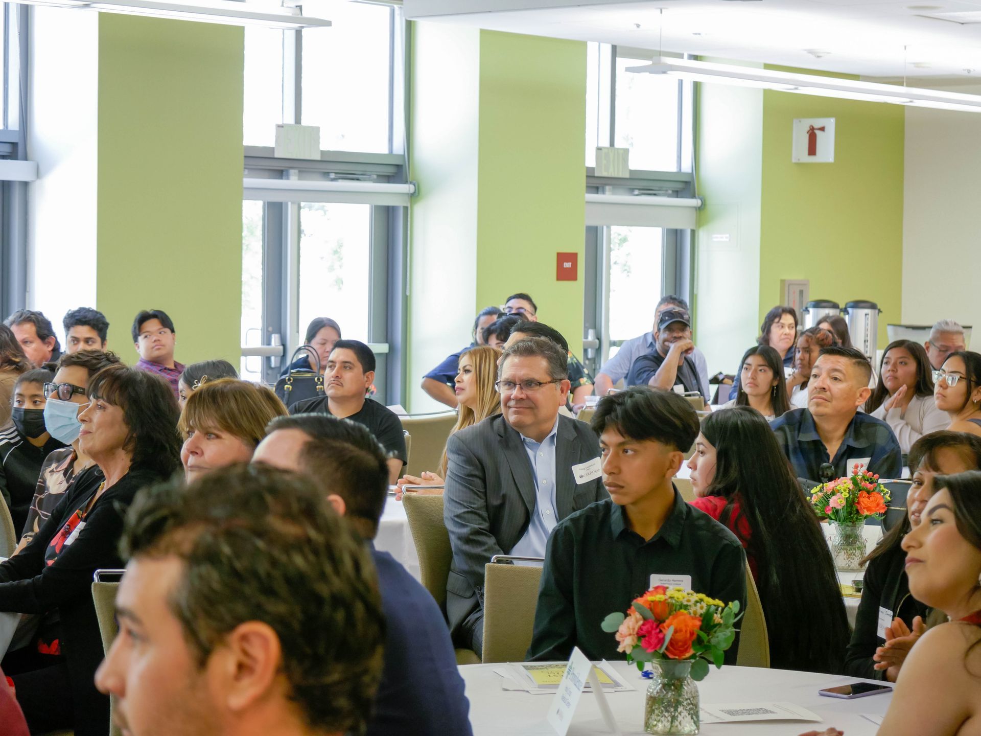 A large group of people are sitting at tables in a room.