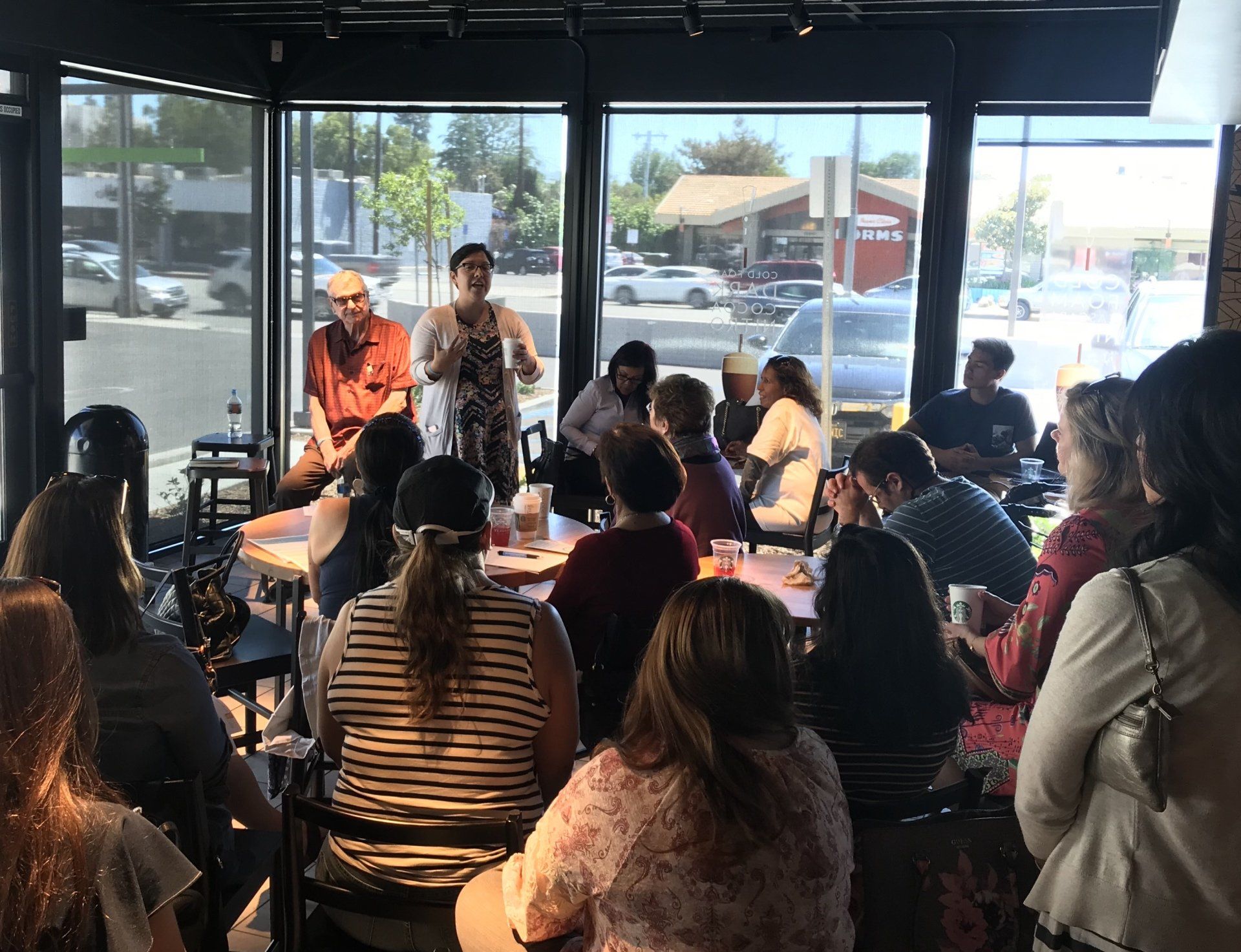 A group of people are sitting at tables in a restaurant.