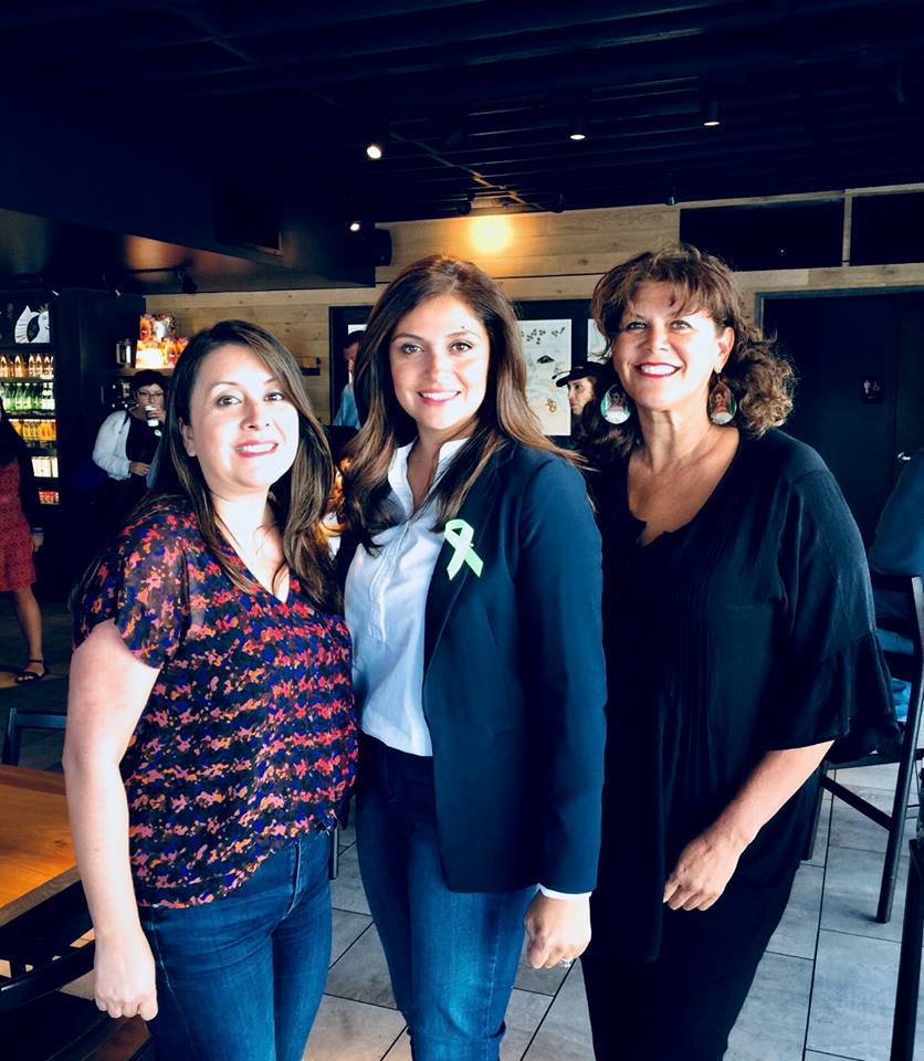 Three women are posing for a picture in a restaurant.