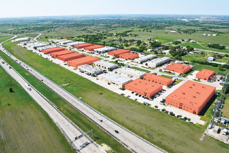 An aerial view of a large industrial area next to a highway.