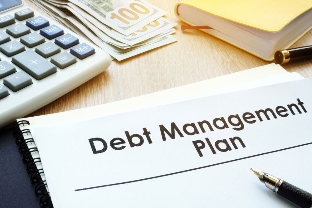A Debt Management Plan is Sitting on a Table Next to a Pen and Calculator — Rauseo Group in Zuccoli, NT