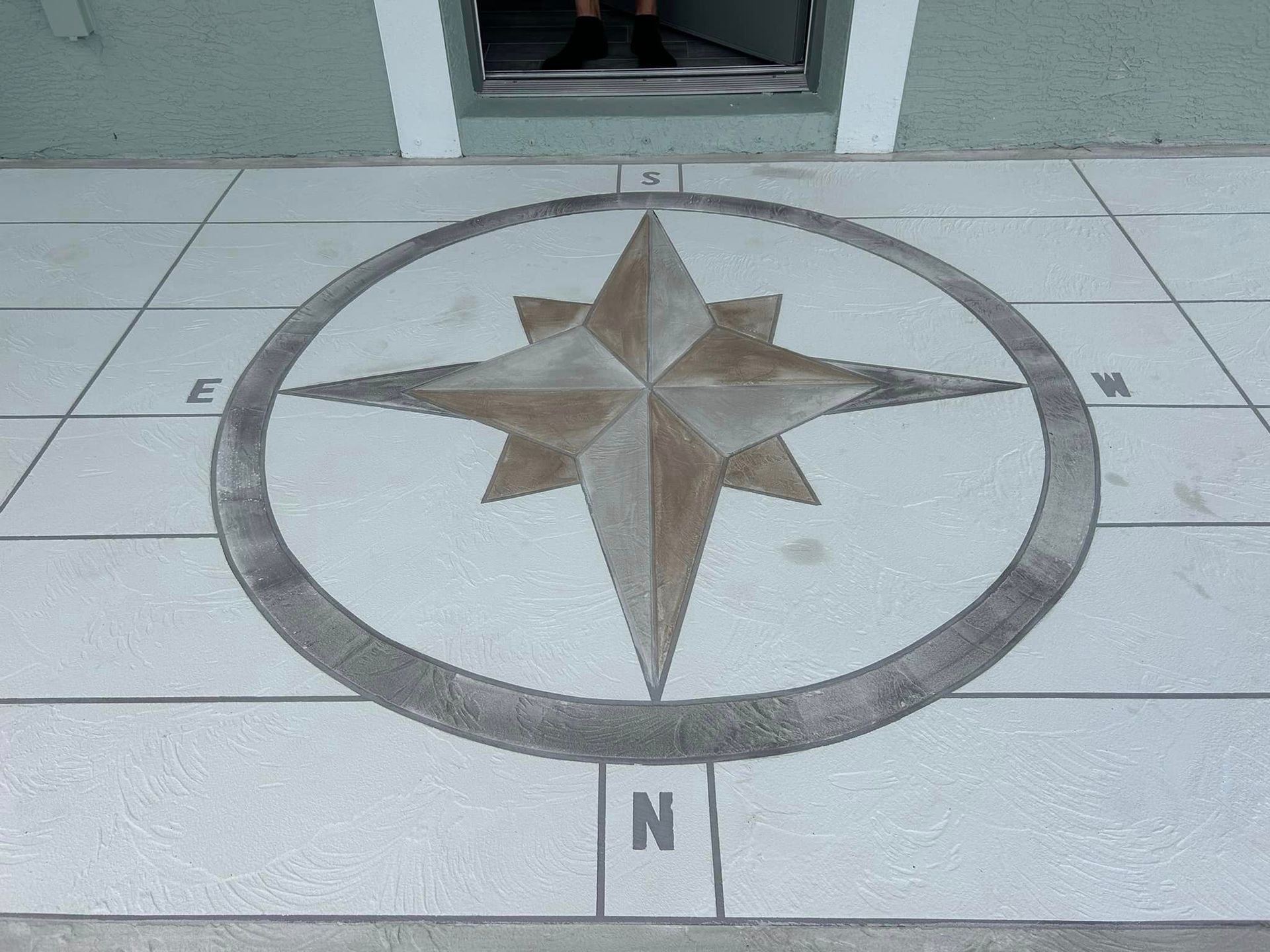 Custom compass design stamped and stained in concrete installation